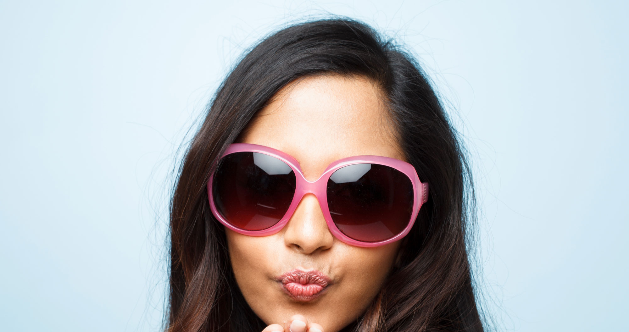 Woman in pink sunglasses posing for the camera