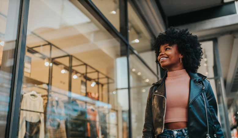 A woman in a leather jacket window shopping