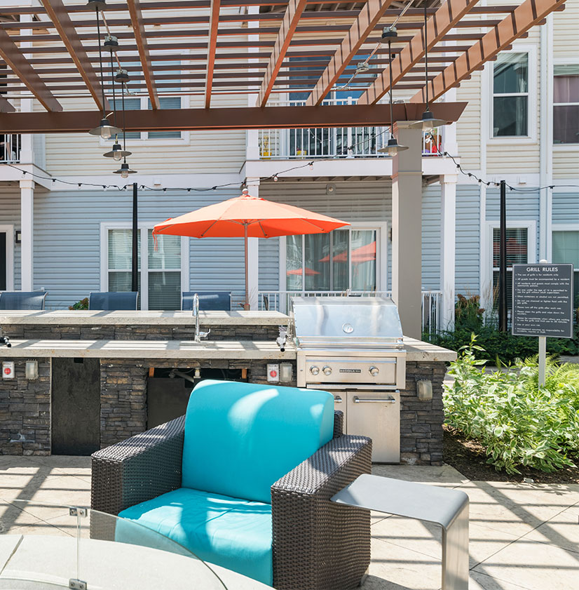 Outdoor grill area with patio lounge furniture and string lights